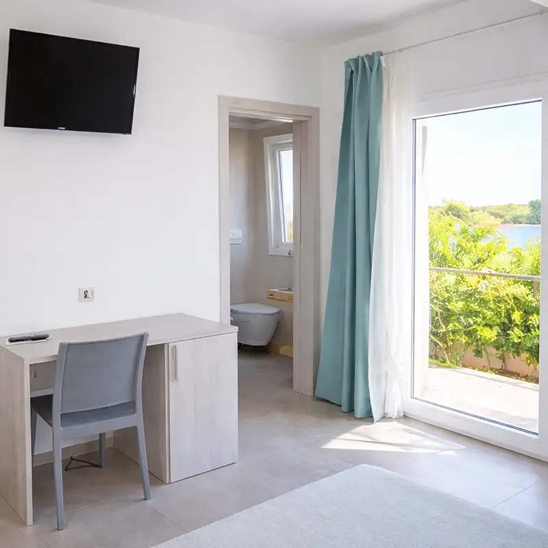 Camera matrimoniale moderna di Tenuta Verdolivo a Ostuni, arredamento minimalista bianco con tocchi di blu.
